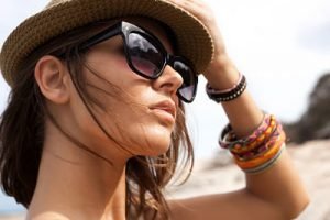Close-up of young summer sexy woman  wearing a hat  and sunglasses. Outdoors lifestyle portrait